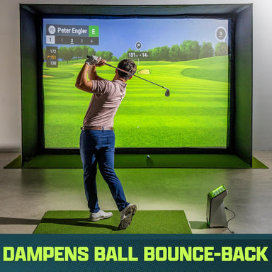 Person playing golf simulation game in a room with a large screen displaying a golf course.