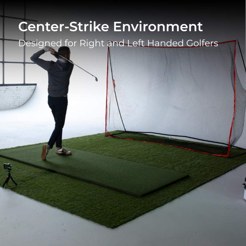 Golfer practicing in a golf simulator with a netted enclosure.