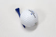 Golf ball with a blue tee on a textured white background