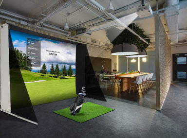 Elite Screens portable golf simulator screens setup in a modern indoor space with a large screen displaying a golf course.