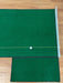 Green golf mat with a white ball on a wooden floor