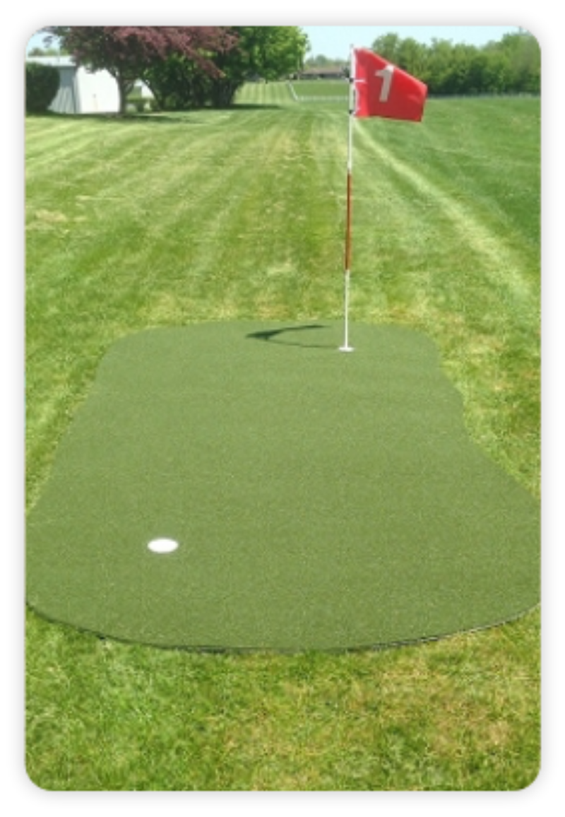 Golf putting green with a red flag on a grassy field