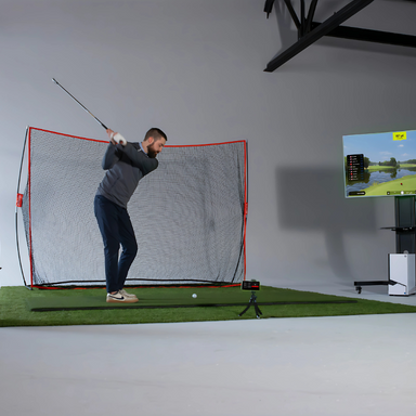 Man practicing golf swing in a room with a screen displaying a golf course.