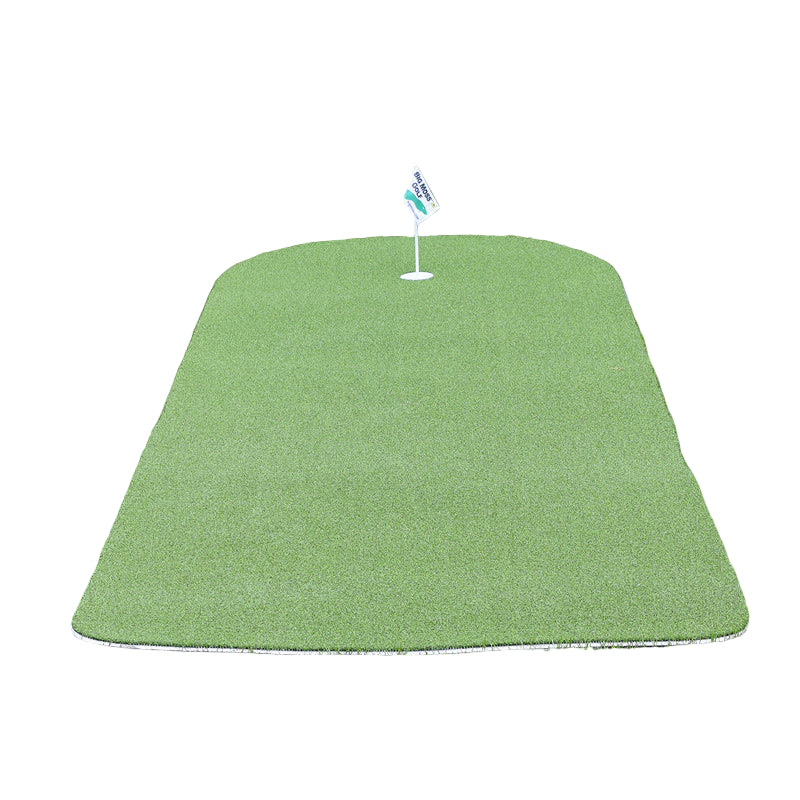Green golf practice mat on grass with a flag