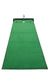 Green golf putting mat with a white circle and black border on a white background
