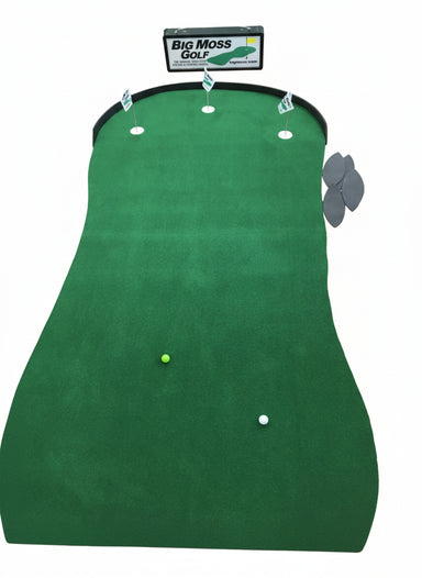 Indoor putting green with golf balls and markers on a wooden floor, featuring Big Moss Golf branding.