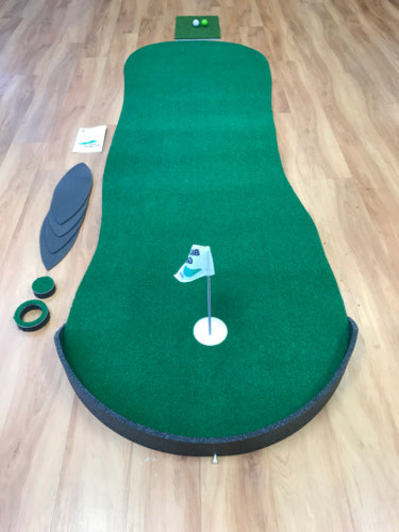 Green putting green mat with accessories on a wooden floor